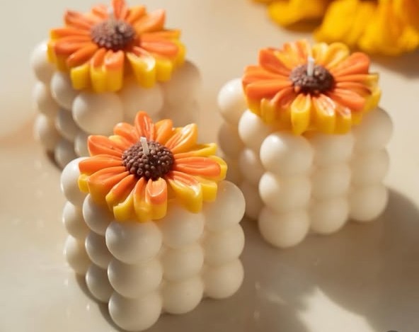 White bubble candles with an orange and yellow flower on top