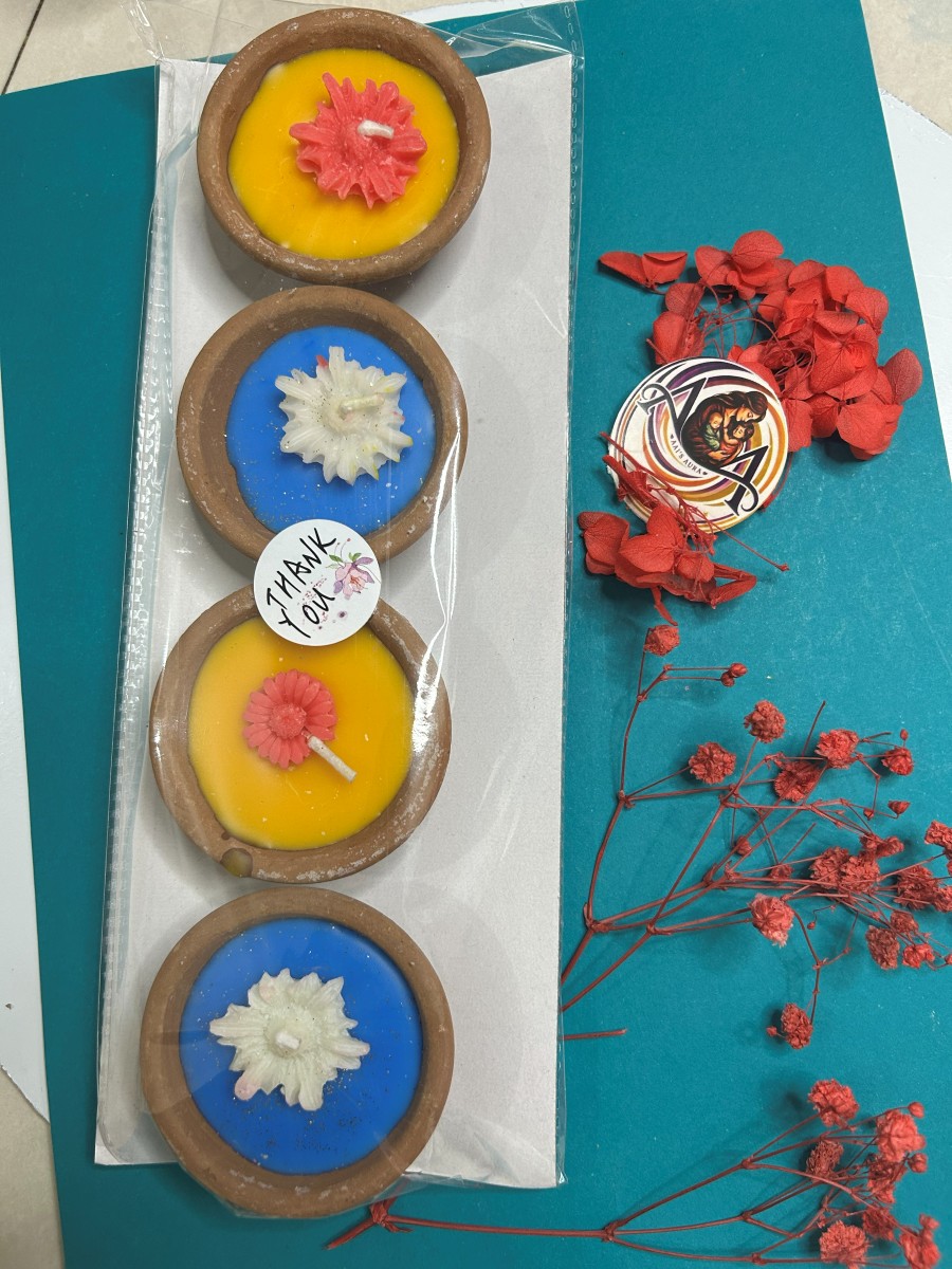 Yellow and red clay diya candles in a pack of four