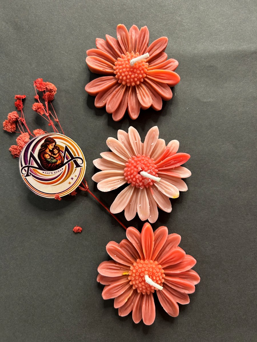 Coral and pink daisy candles photographed as a group of three