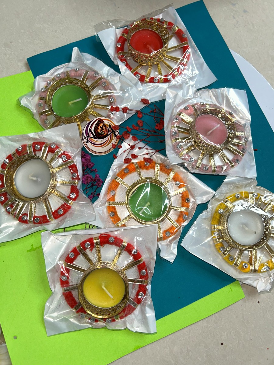 Several packed decorative diyas in red, orange, pink, and yellow thread