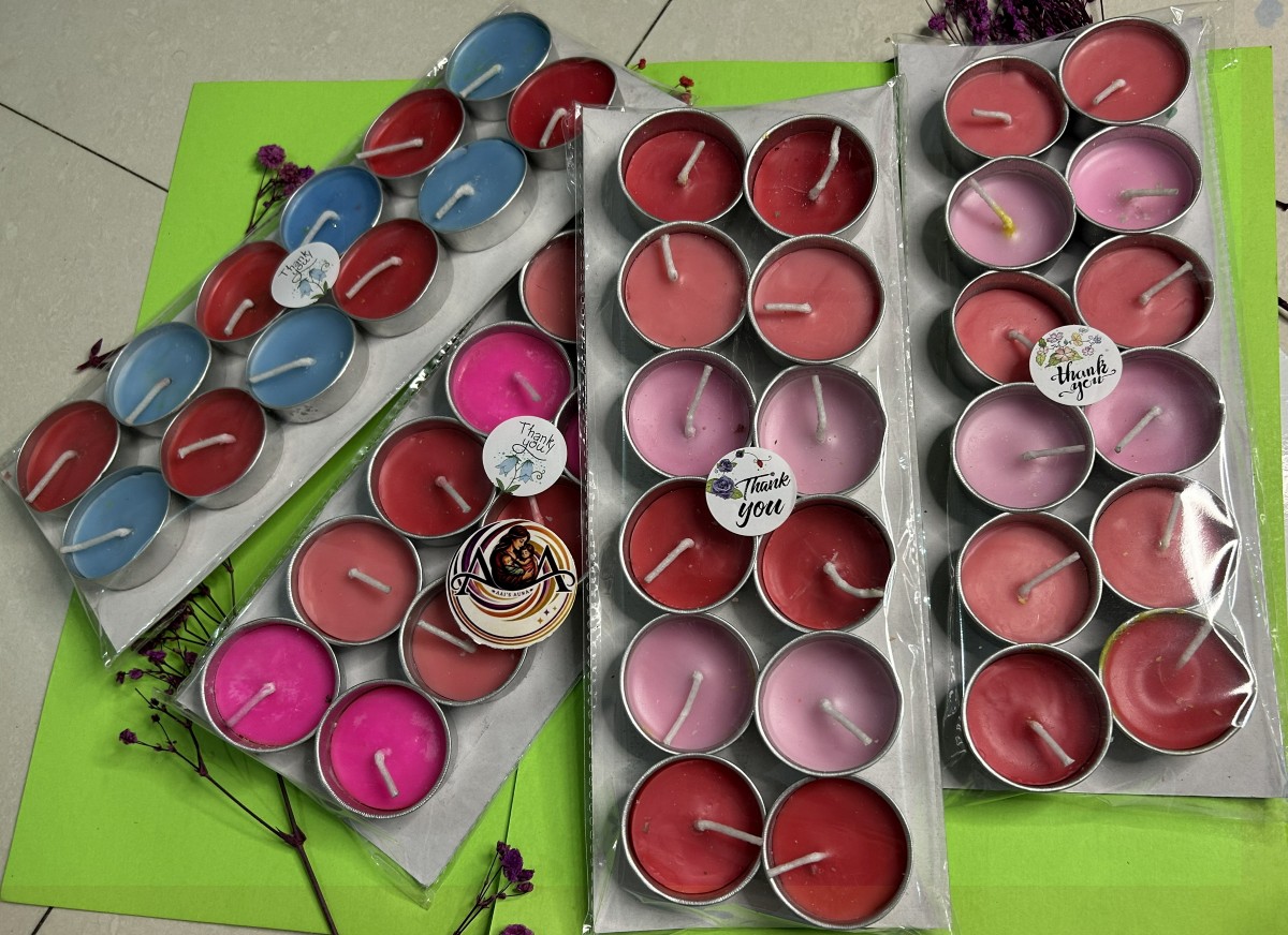 Several packs of simple twelve-piece tea lights in pink, red, and blue