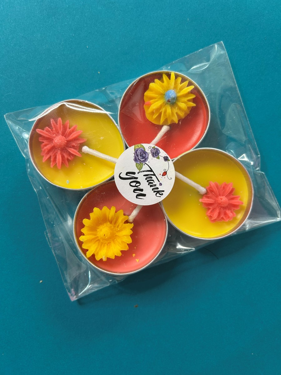 Pack of four red and yellow decorative tea lights with wax flowers