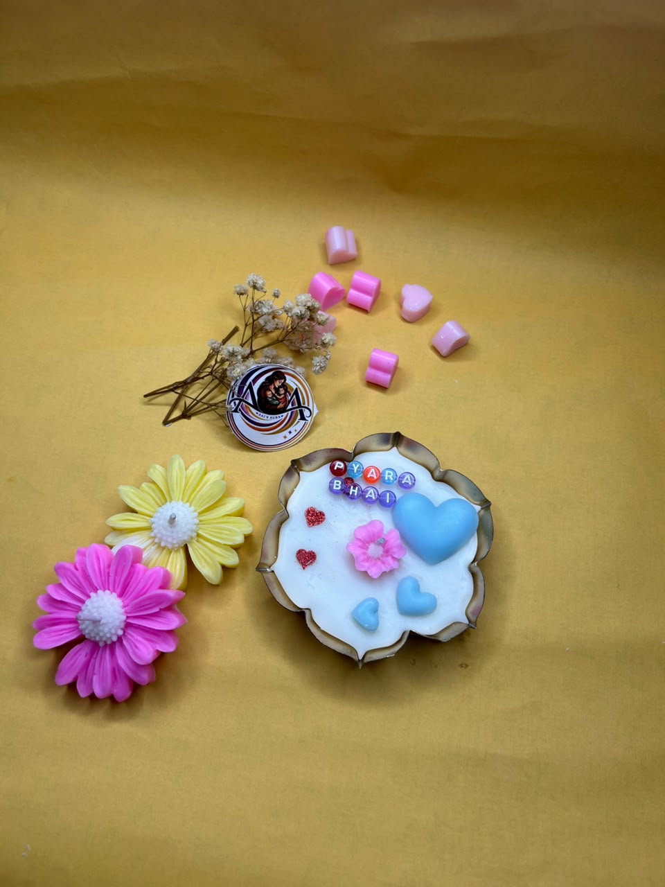 One urli with two daisy candles, one pink and one yellow